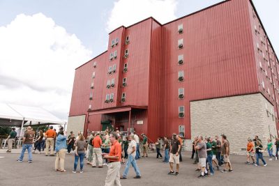 Employees arriving to a company event with a warehouse in the background